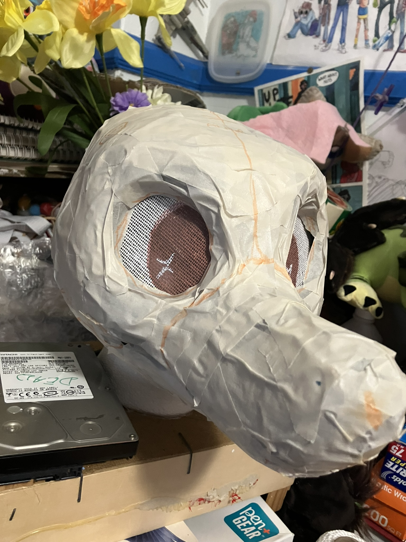 a fursuit face "worm on a string" base that has been taped up, and the tape is marked with lines on where it will be cut and turned into a fabric pattern.